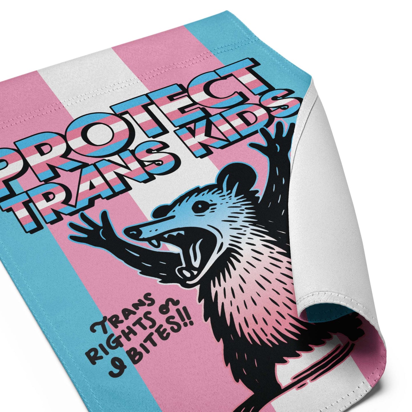Close-up of Protect Trans Kids Garden Flag with possum illustration