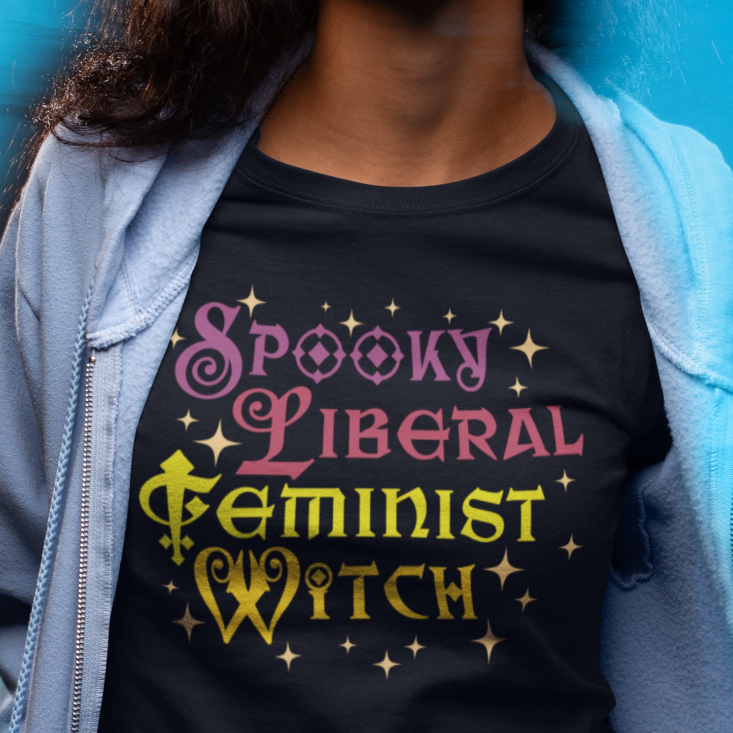 Model wearing “Spooky Liberal Feminist Witch” graphic tee layered with denim, Blue Wave USA progressive apparel for Halloween season.
