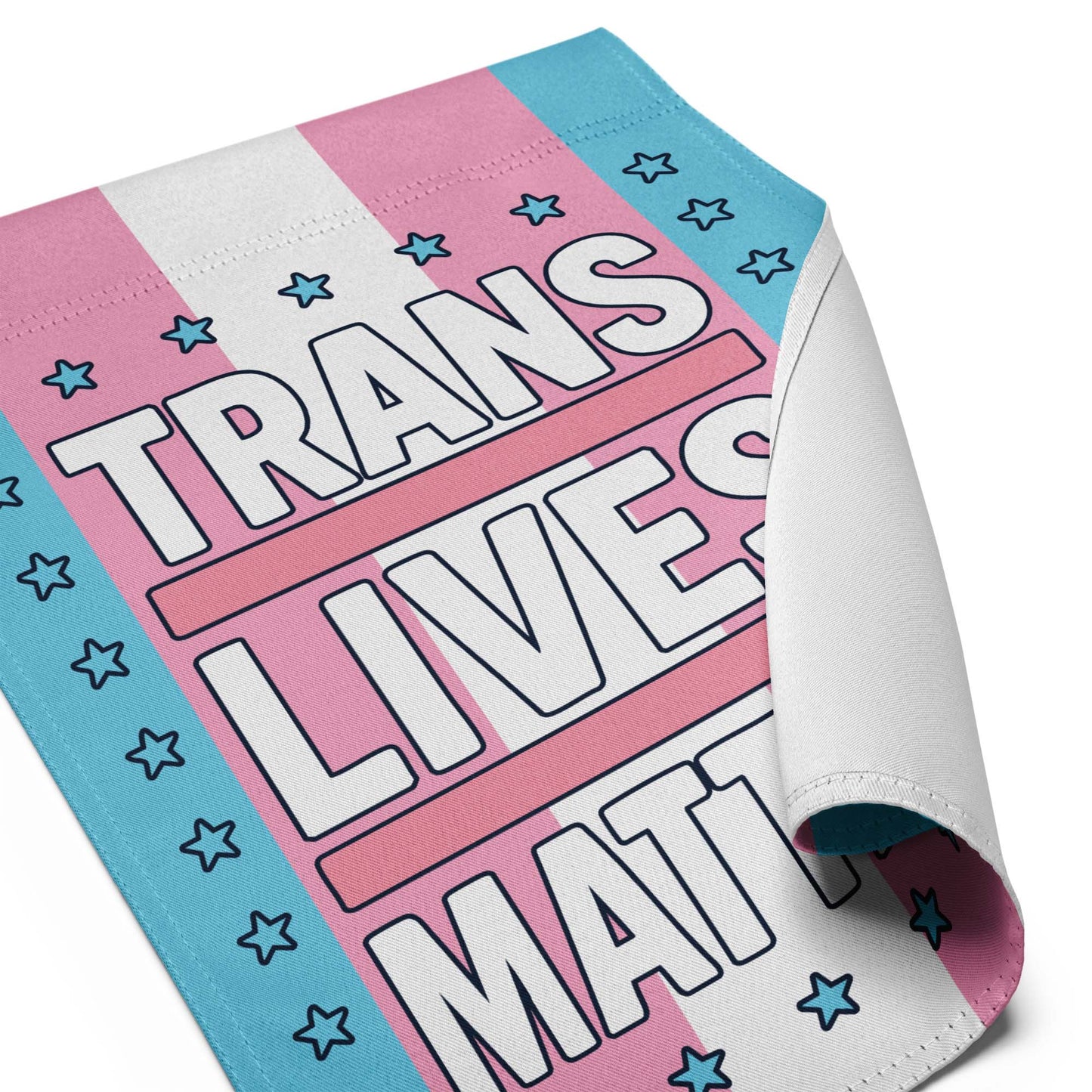 Close-Up of Design: Close-up of Trans Lives Matter Garden Flag with stars and bold activist lettering
