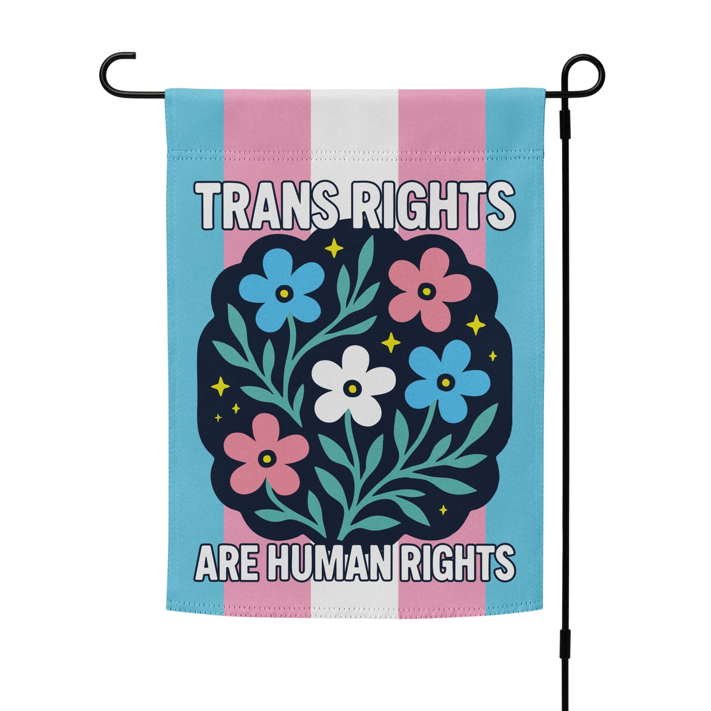 Garden flag displayed vertically on a black metal stand, featuring a floral folk-art design over trans pride colors with the message “TRANS RIGHTS ARE HUMAN RIGHTS,” from Blue Wave USA.