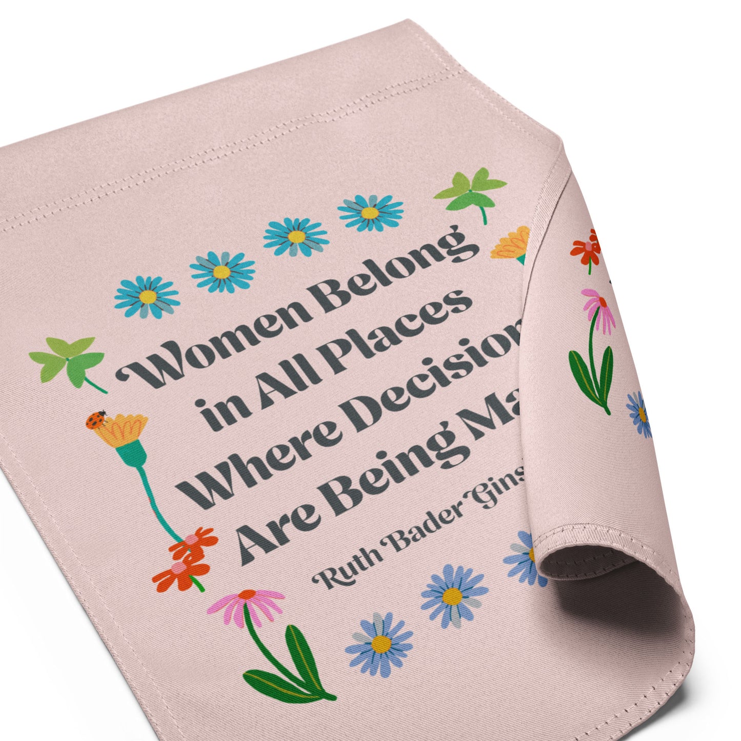 Folded garden flag shown flat, highlighting the floral illustrations, pastel color palette, and serif typography reading “Women Belong in All Places Where Decisions Are Being Made.”