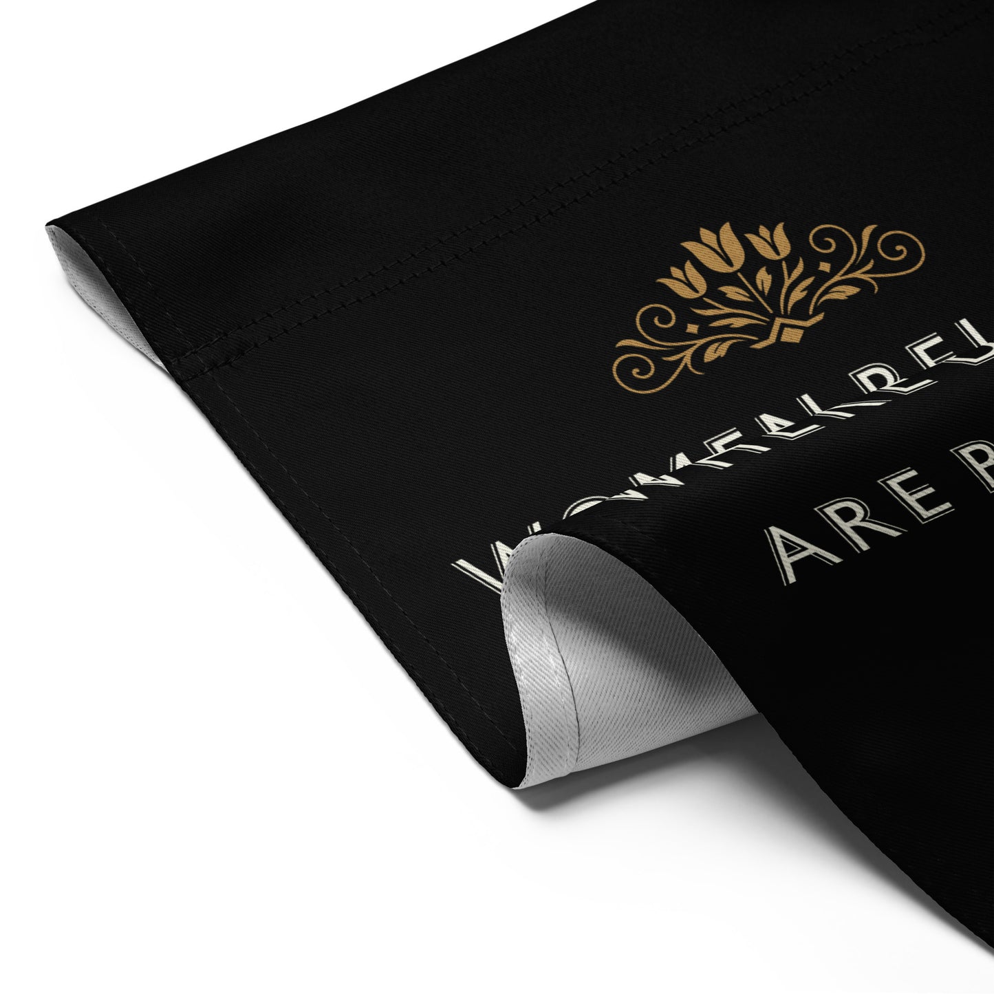 Detailed corner view of the “Women Belong In All Places Where Decisions Are Being Made” Ruth Bader Ginsburg garden flag on black fabric with gold accents.