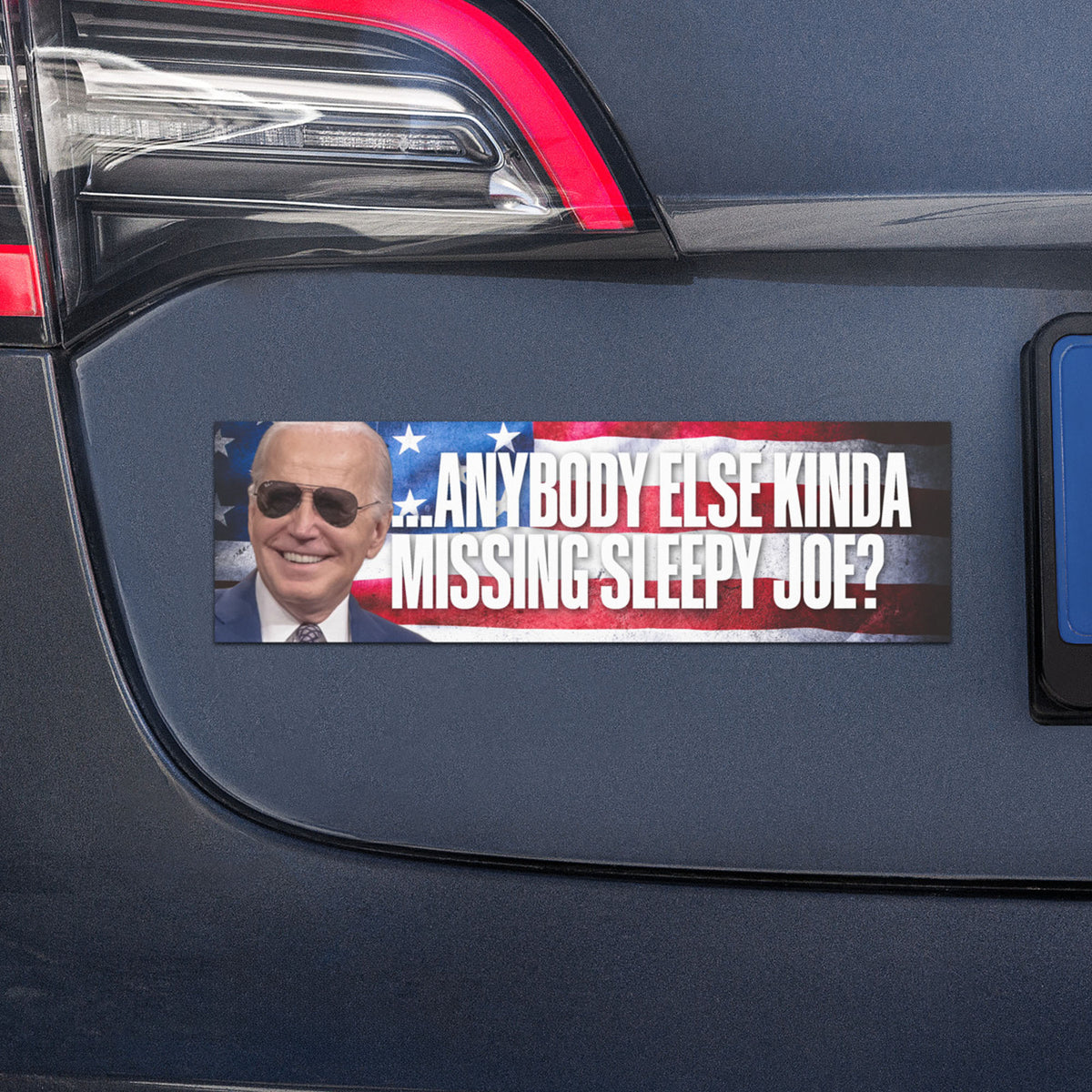Car magnet featuring Joe Biden with the phrase “Anybody Else Kinda Missing Sleepy Joe?” over a patriotic stars-and-stripes background, displayed on a dark-colored vehicle.