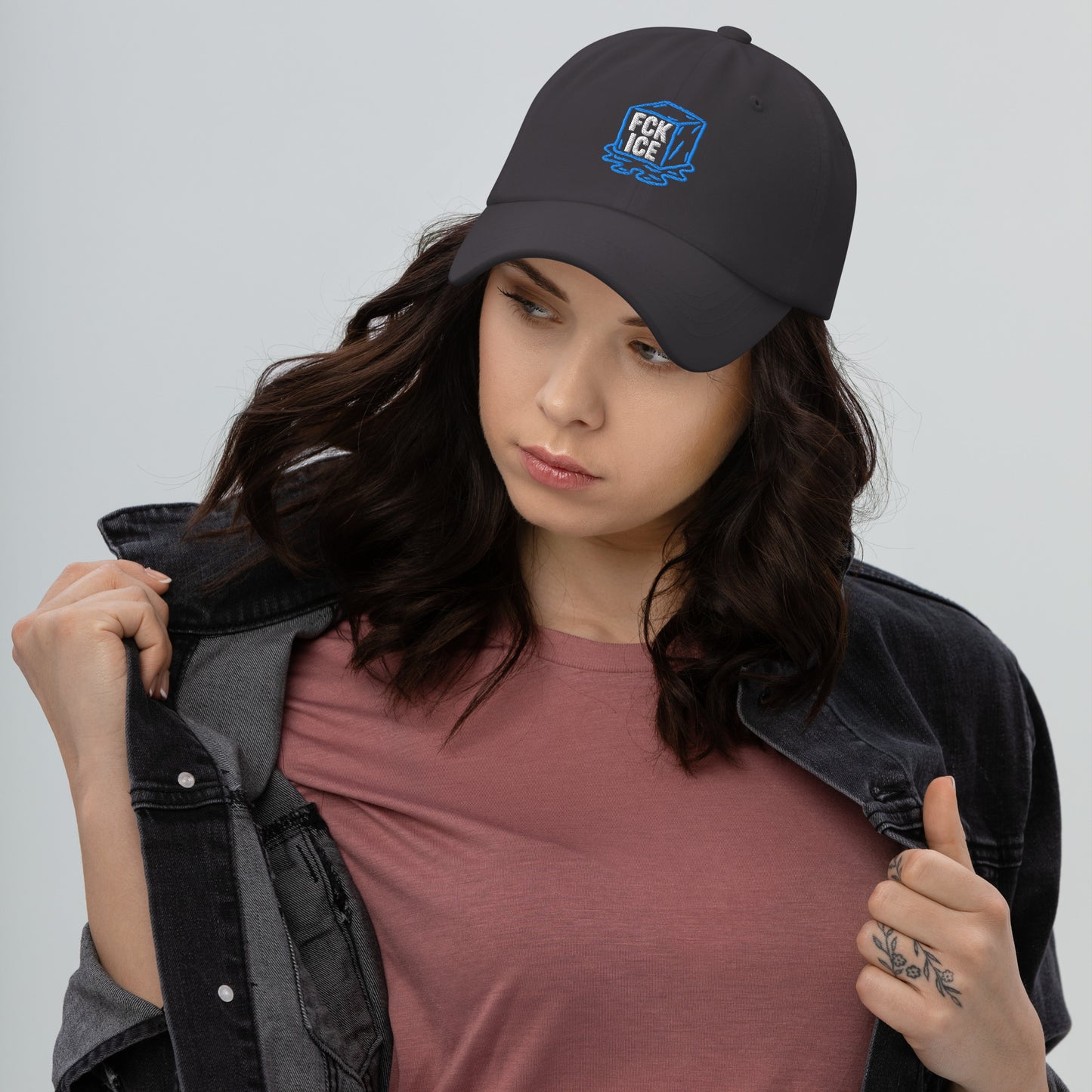 Lifestyle Image: Woman wearing embroidered F*CK ICE melting cube graphic protest hat with abolitionist design