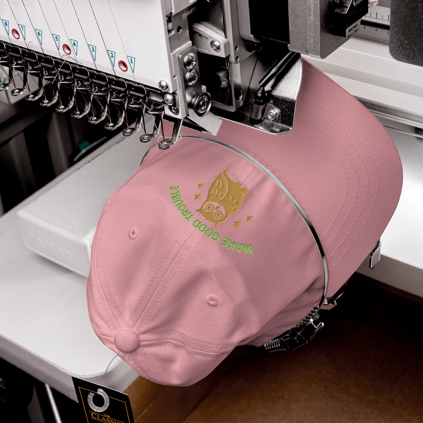 The Make Good Trouble hat featuring owl and embroidered civil rights message being embroidered on a hat