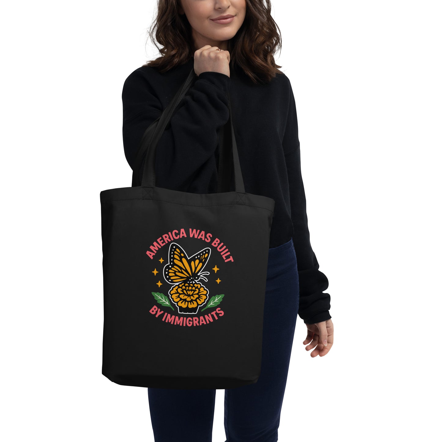 Model carrying black “America Was Built by Immigrants” eco tote bag, Blue Wave USA activist accessory for equality and diversity.