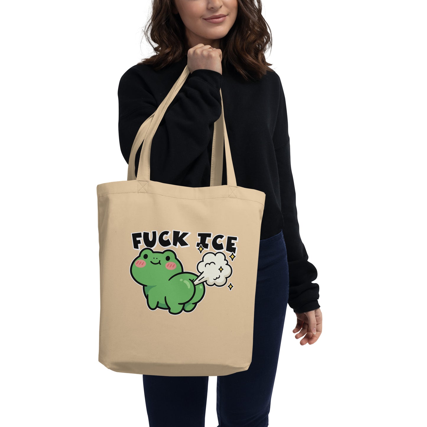 Model carrying natural canvas eco tote featuring cartoon frog with gas cloud and “Fuck ICE” phrase in playful activist style.