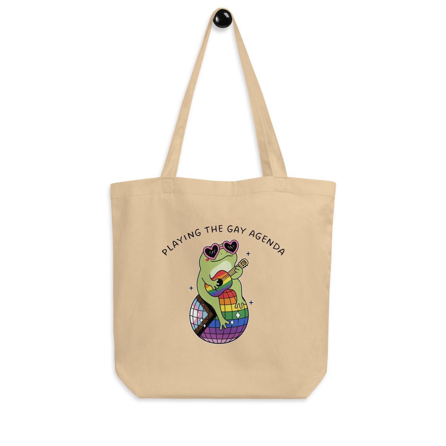 Natural eco tote bag displaying a fashionable frog in heart-shaped sunglasses with rainbow disco ball artwork and playful LGBTQ+ pride message.