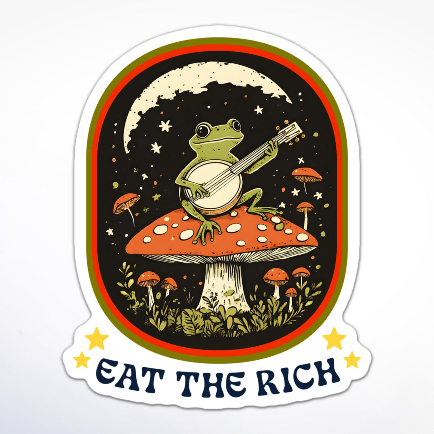 Cottagecore-inspired anti-capitalism sticker with a banjo-playing frog atop a toadstool and protest slogan “Eat The Rich.”