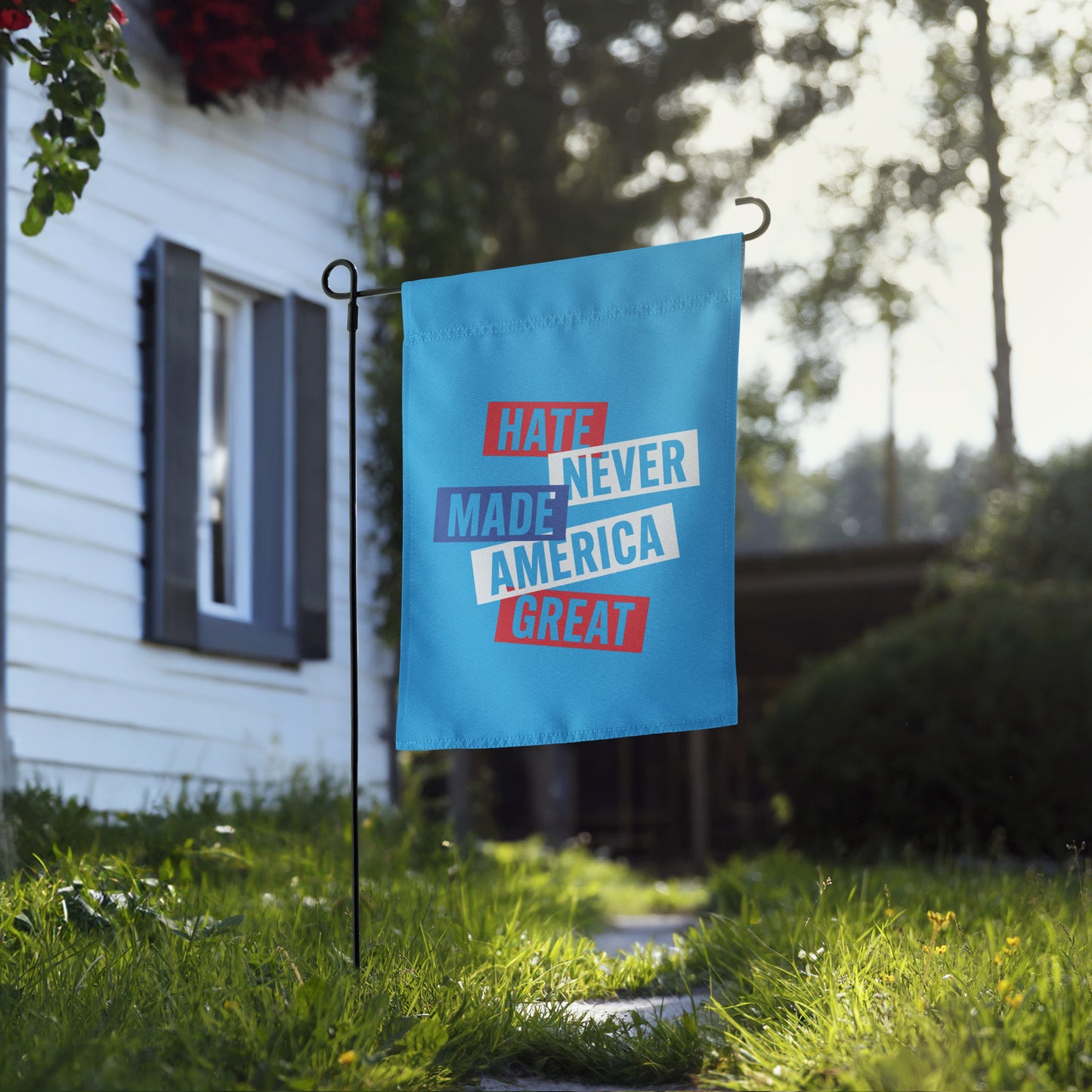 Front View Image: Full display of the Hate Never Made America Great garden flag in a vibrant yard.