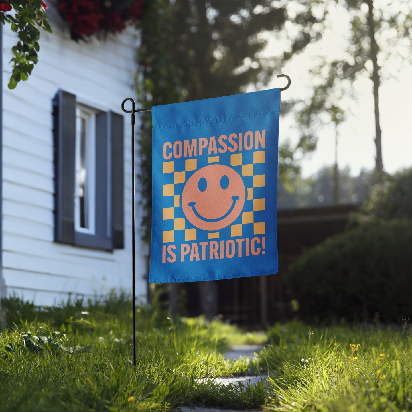 Compassion Is Patriotic! Social Justice Patriotic Kindness progressive garden flag displayed out in the yard.