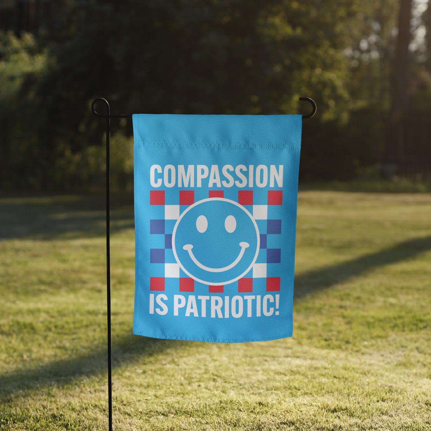 Front view of the Compassion Is Patriotic Smiley Face Garden Flag in vibrant red, white, and blue with a smiley face design.