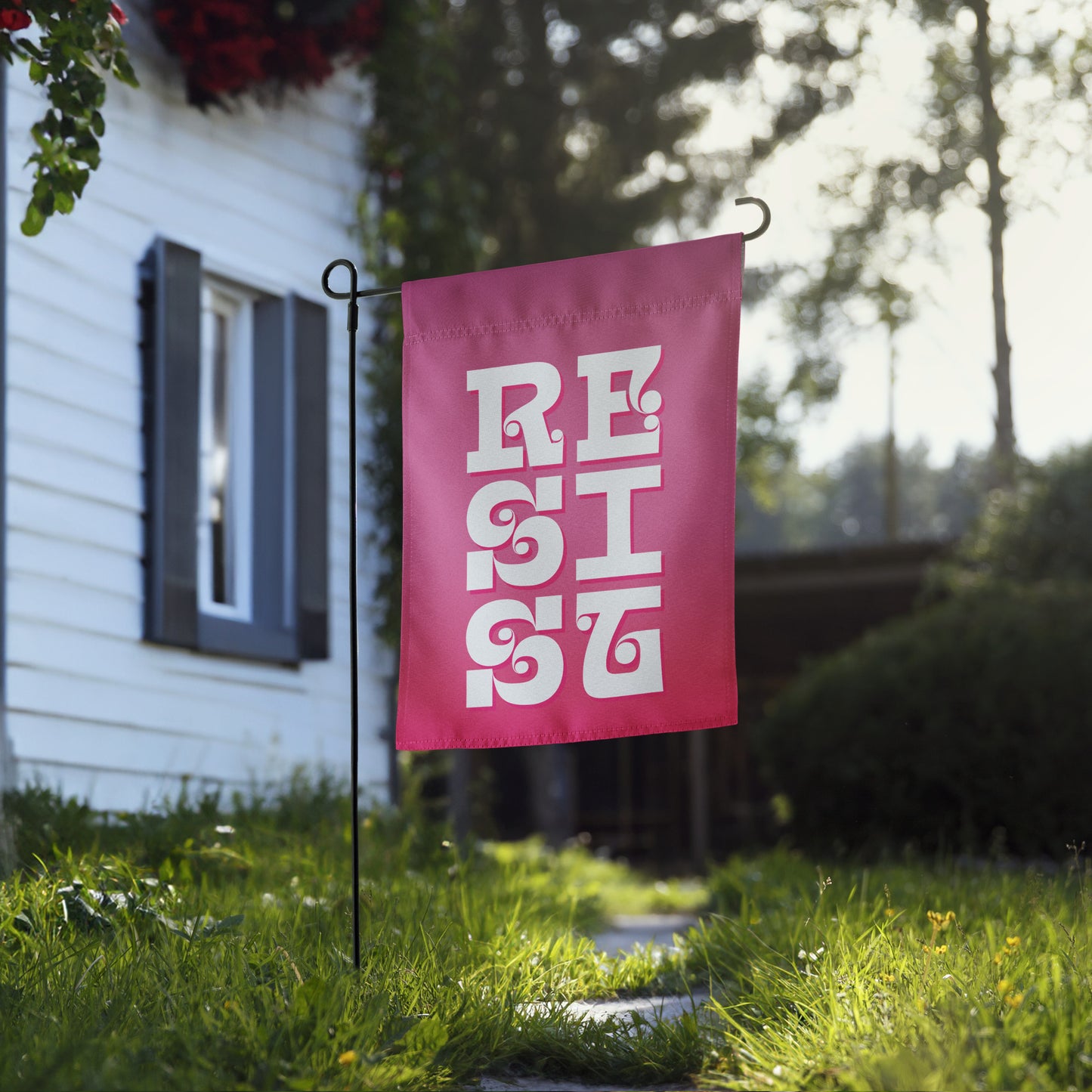 Front View Image: RESIST Garden Flag displayed in a vibrant green garden.