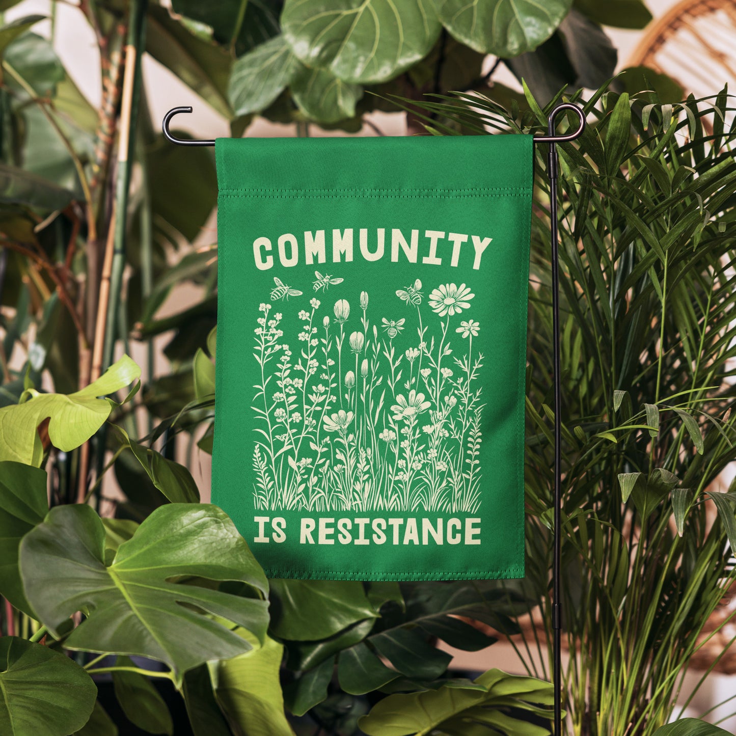 Front View Image: Vibrant Community Is Resistance Progressive Garden Flag standing in a garden display.
