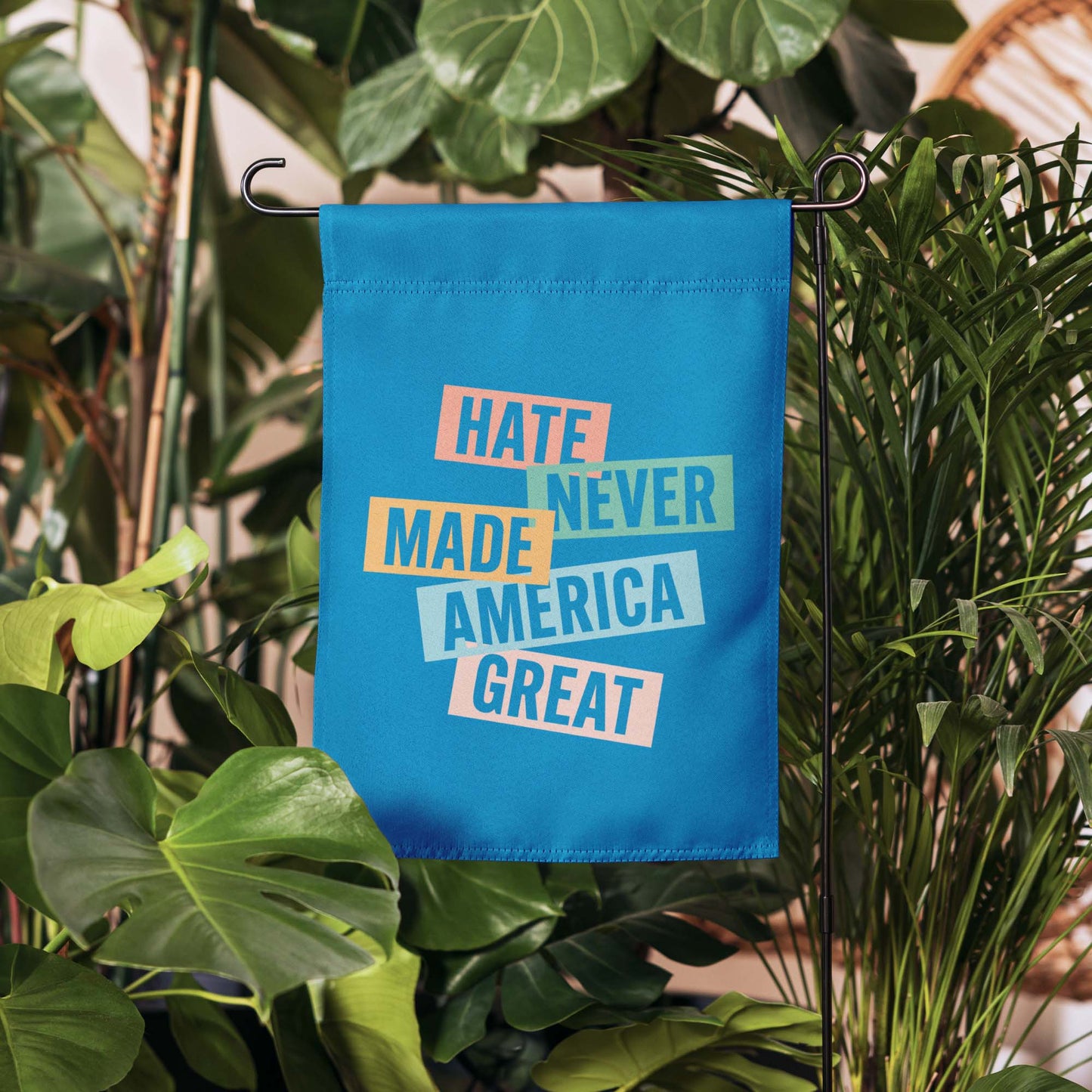 Front View Image: Full display of the progressive Hate Never Made America Great garden flag in a backyard