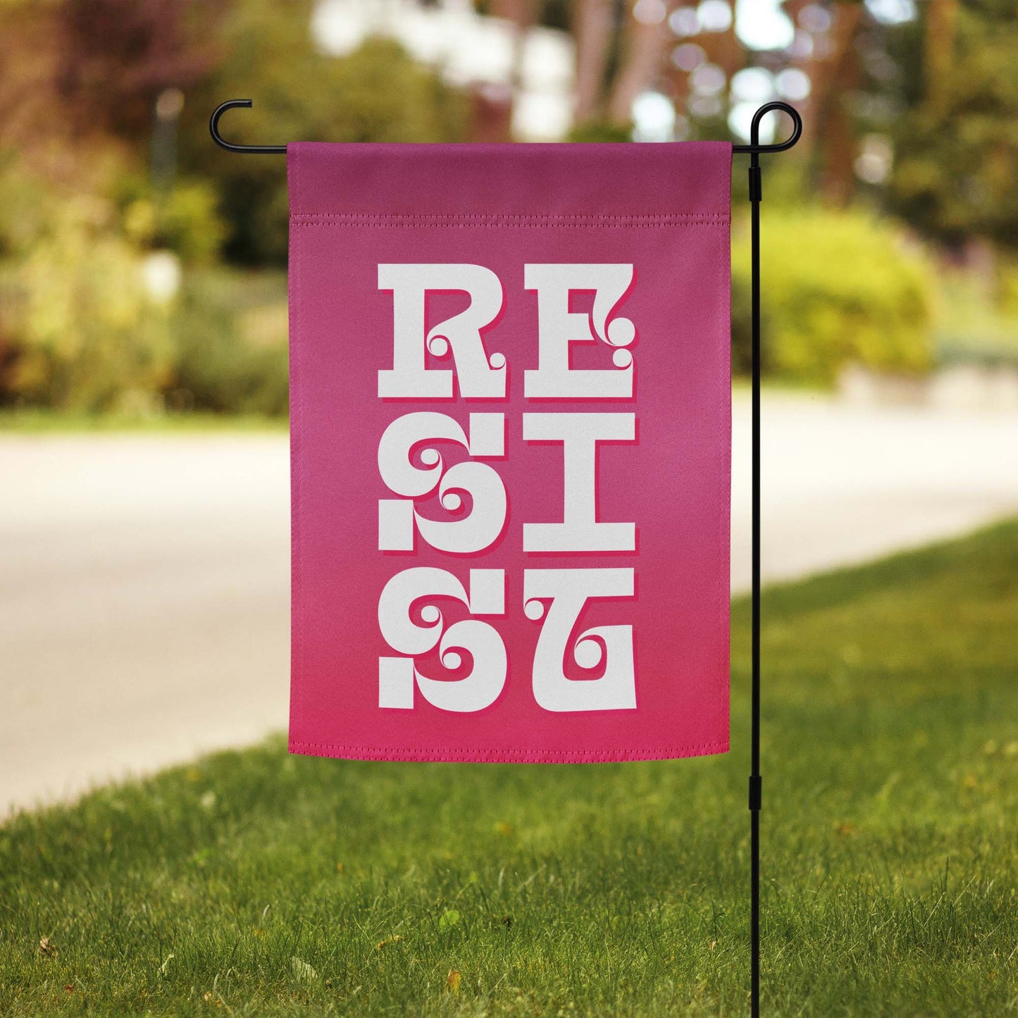 Front View Image: RESIST Garden Flag displayed in a vibrant green garden.
