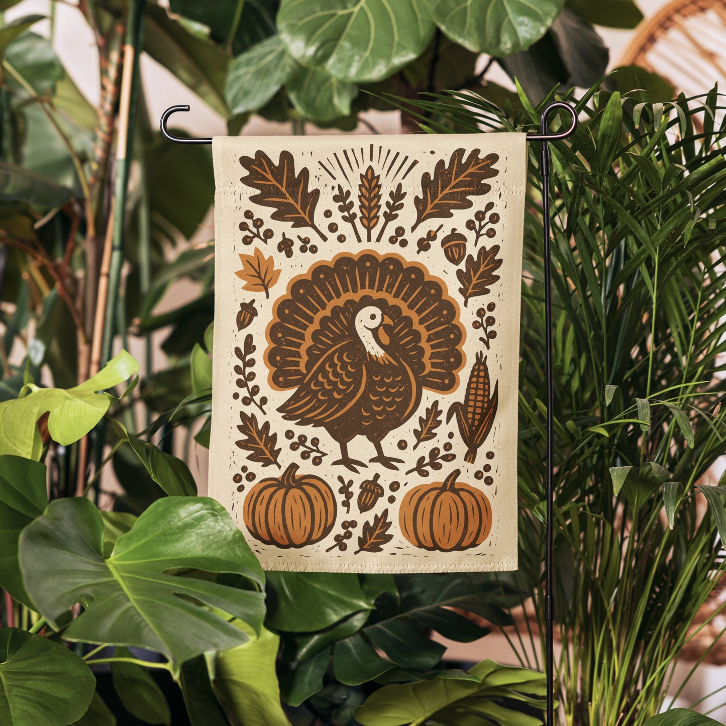 Thanksgiving garden flag with turkey, pumpkins, and leaves in folk-art style design, hung among greenery.
