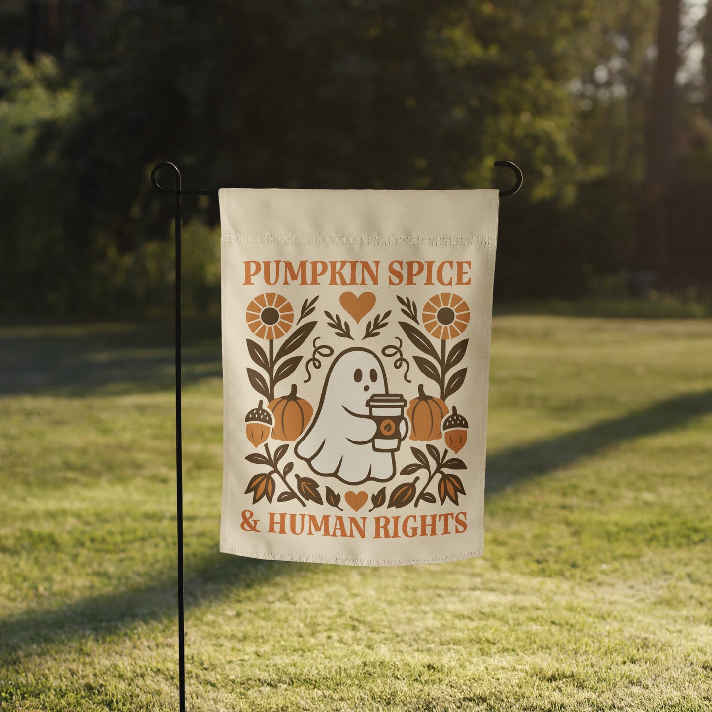 Progressive Thanksgiving garden flag reading “Pumpkin Spice & Human Rights” shown on a flag stand in a grassy yard.