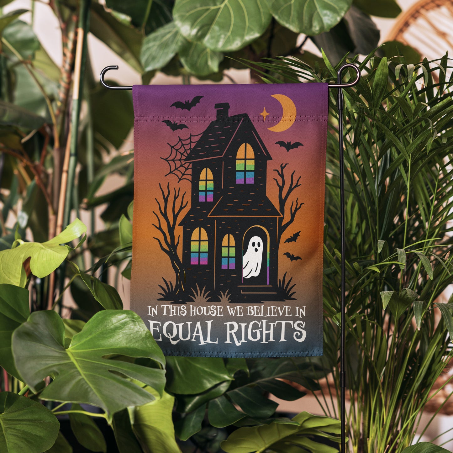 Progressive Halloween garden flag with haunted house and rainbow-lit windows symbolizing LGBTQ+ Pride, sold by Blue Wave USA activist décor.