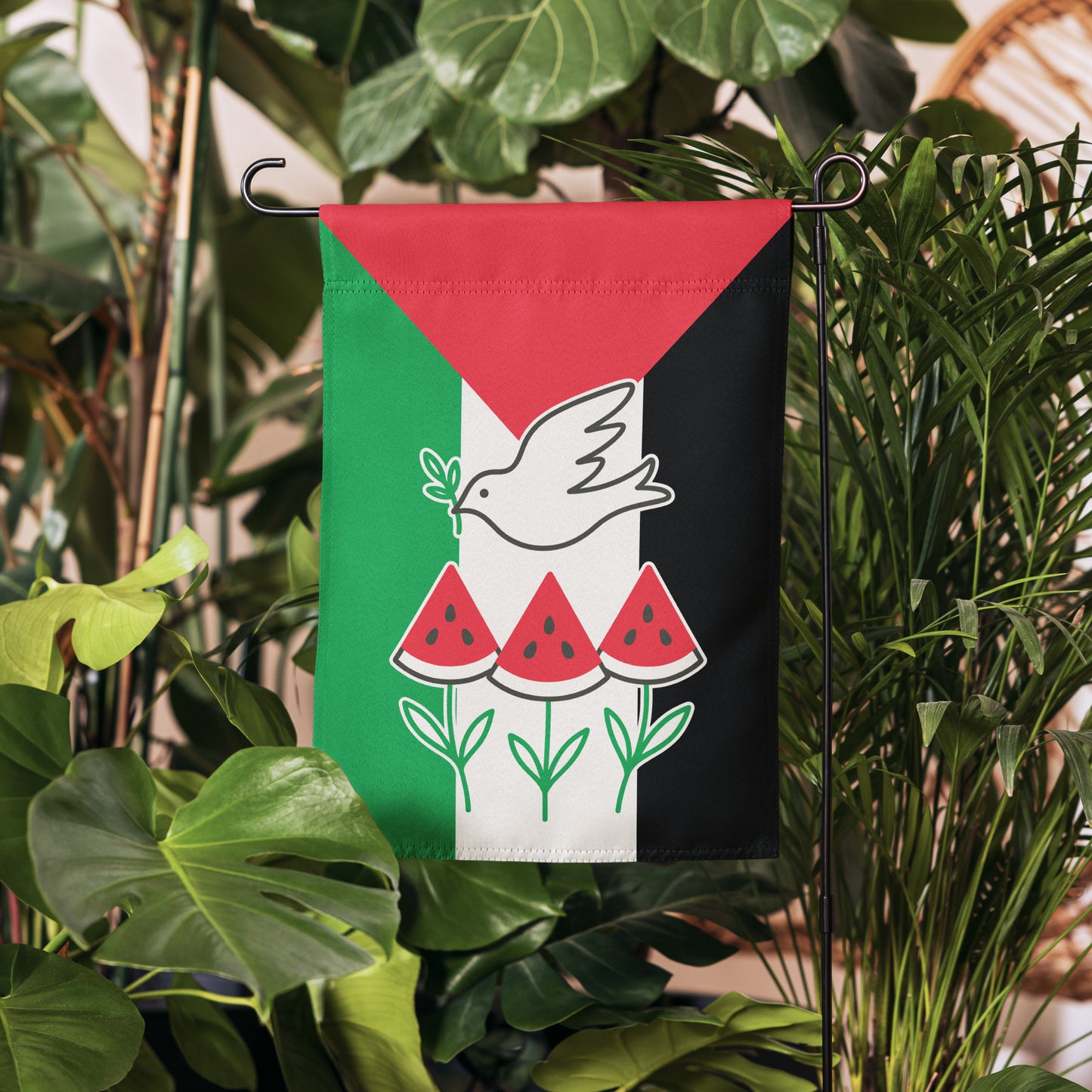 Progressive Free Palestine activist garden flag with dove and watermelon design, shown hanging among greenery.