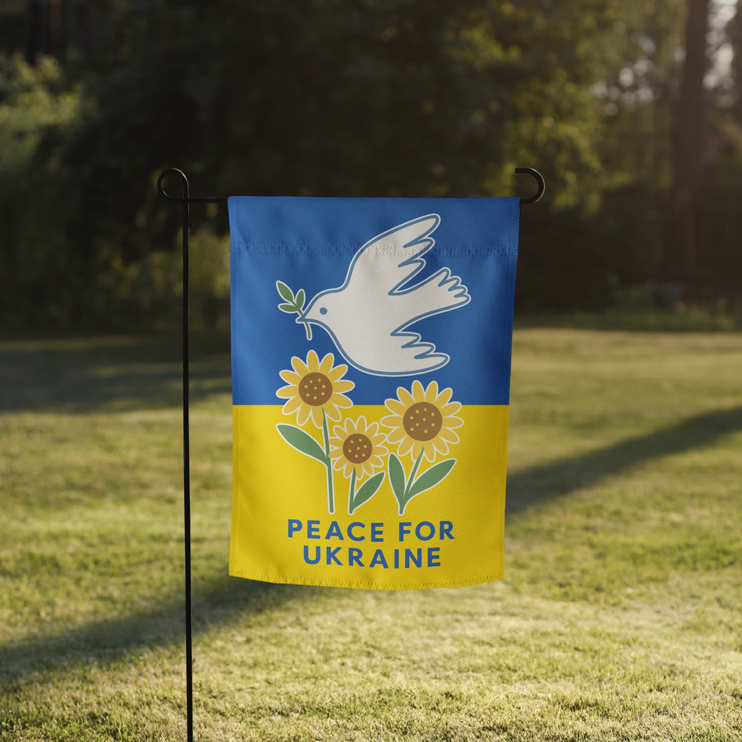Progressive “Peace for Ukraine” garden flag with dove and sunflower design, shown on a flag stand in grassy yard.