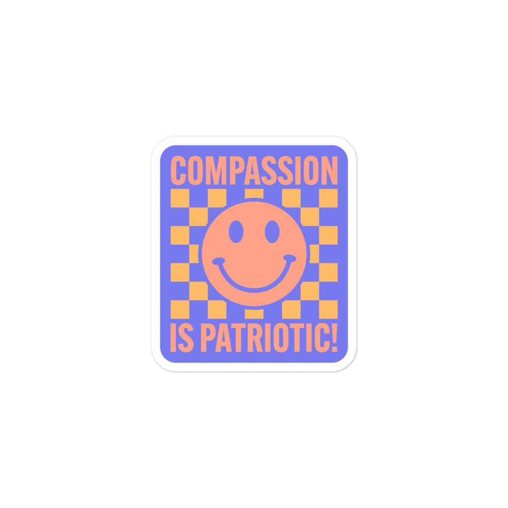 Close-up of the smiley face and text Compassion Is Patriotic on the sticker.
