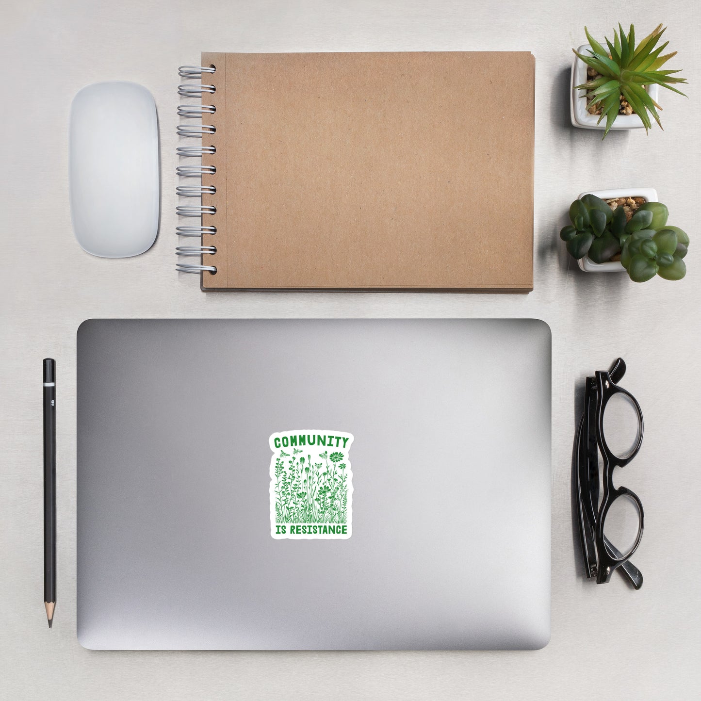 Lifestyle Image: Community Is Resistance Sticker displayed on a laptop