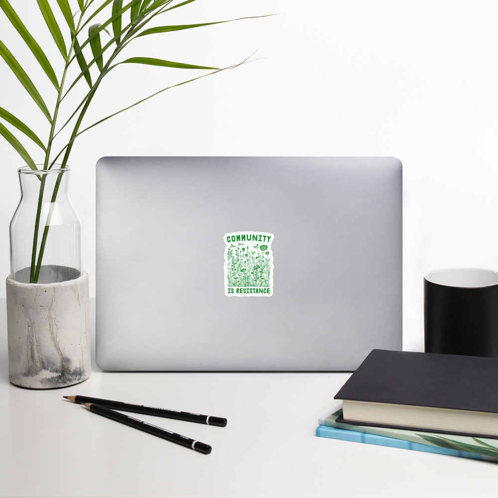 Lifestyle Image: Community Is Resistance Sticker displayed on a laptop
