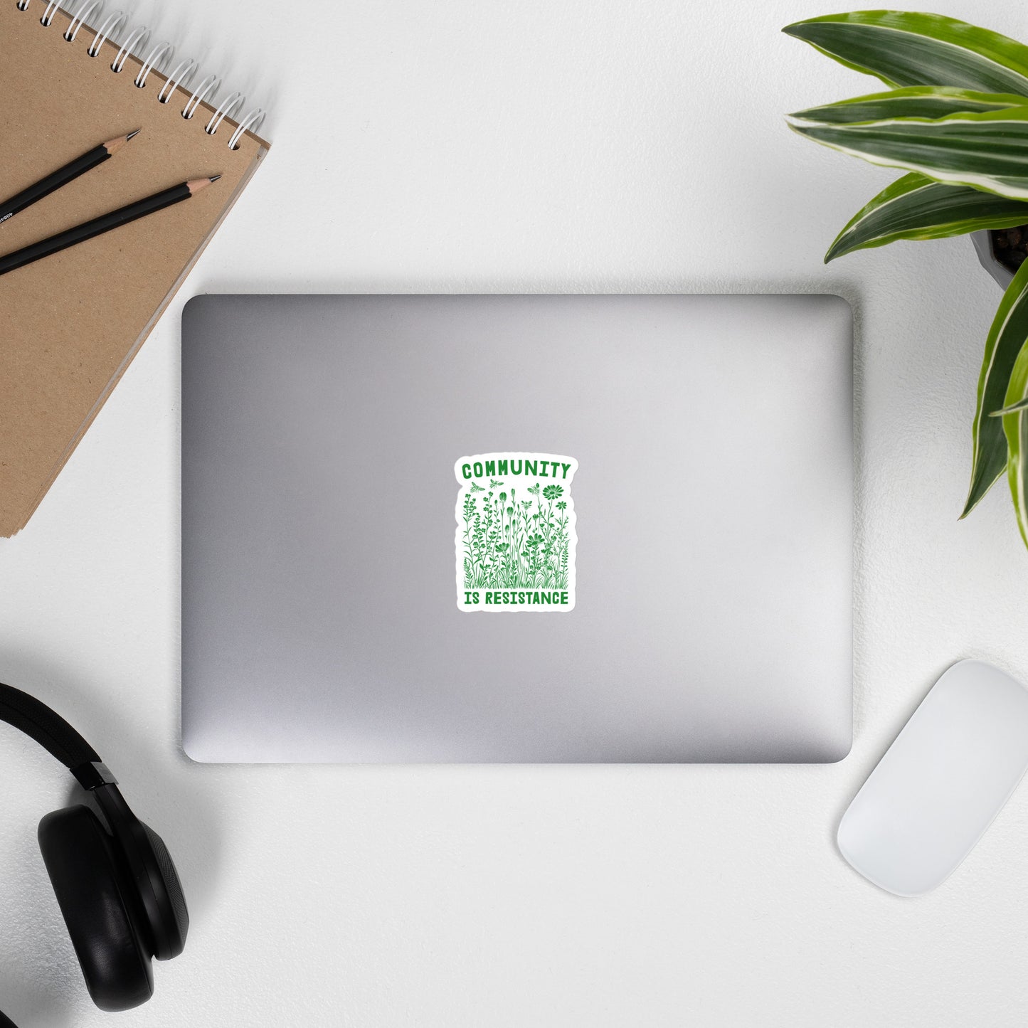 Lifestyle Image: Community Is Resistance Sticker displayed on a laptop