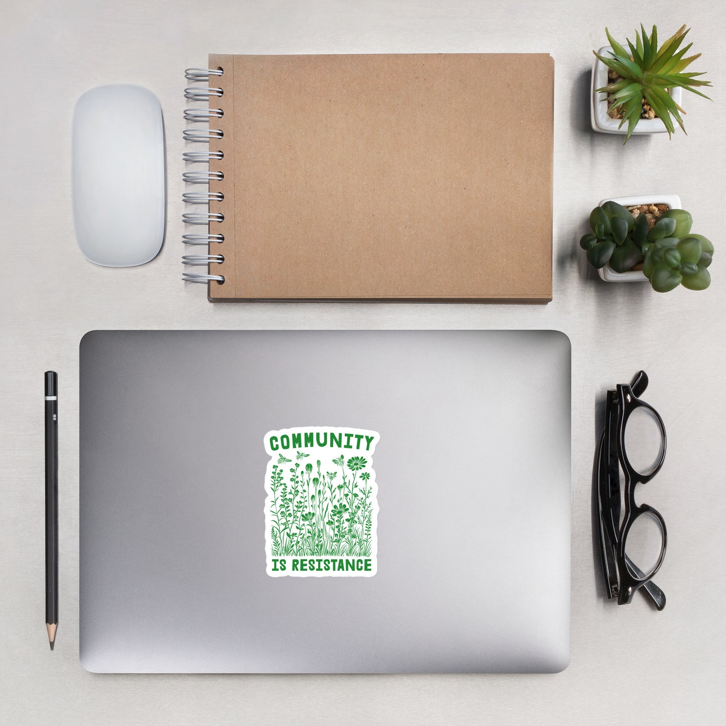Lifestyle Image: Community Is Resistance Sticker displayed on a laptop