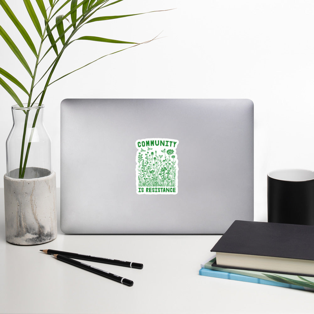 Lifestyle Image: Community Is Resistance Sticker displayed on a laptop