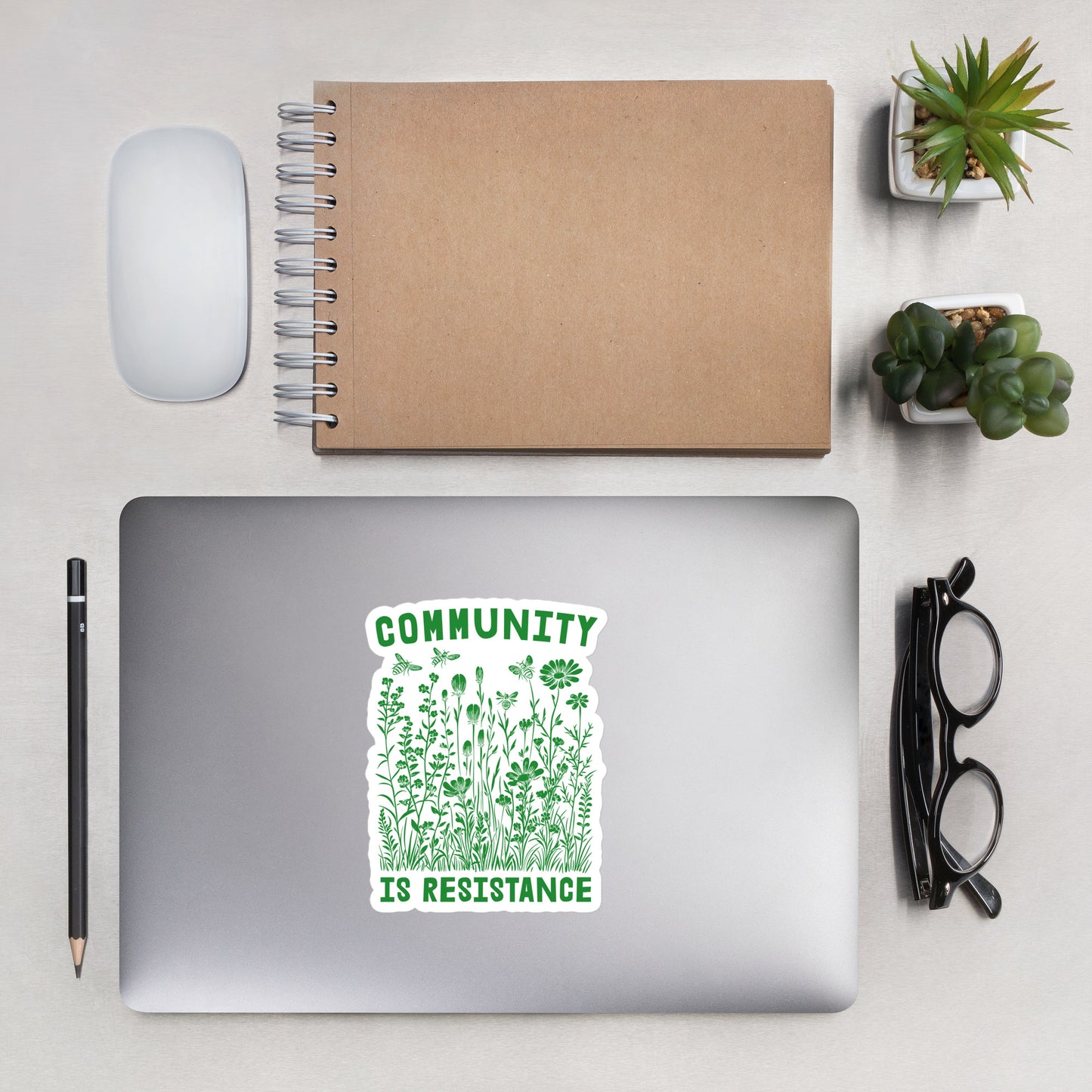 Lifestyle Image: Community Is Resistance Sticker displayed on a laptop