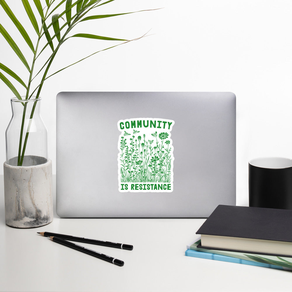 Lifestyle Image: Community Is Resistance Sticker displayed on a laptop