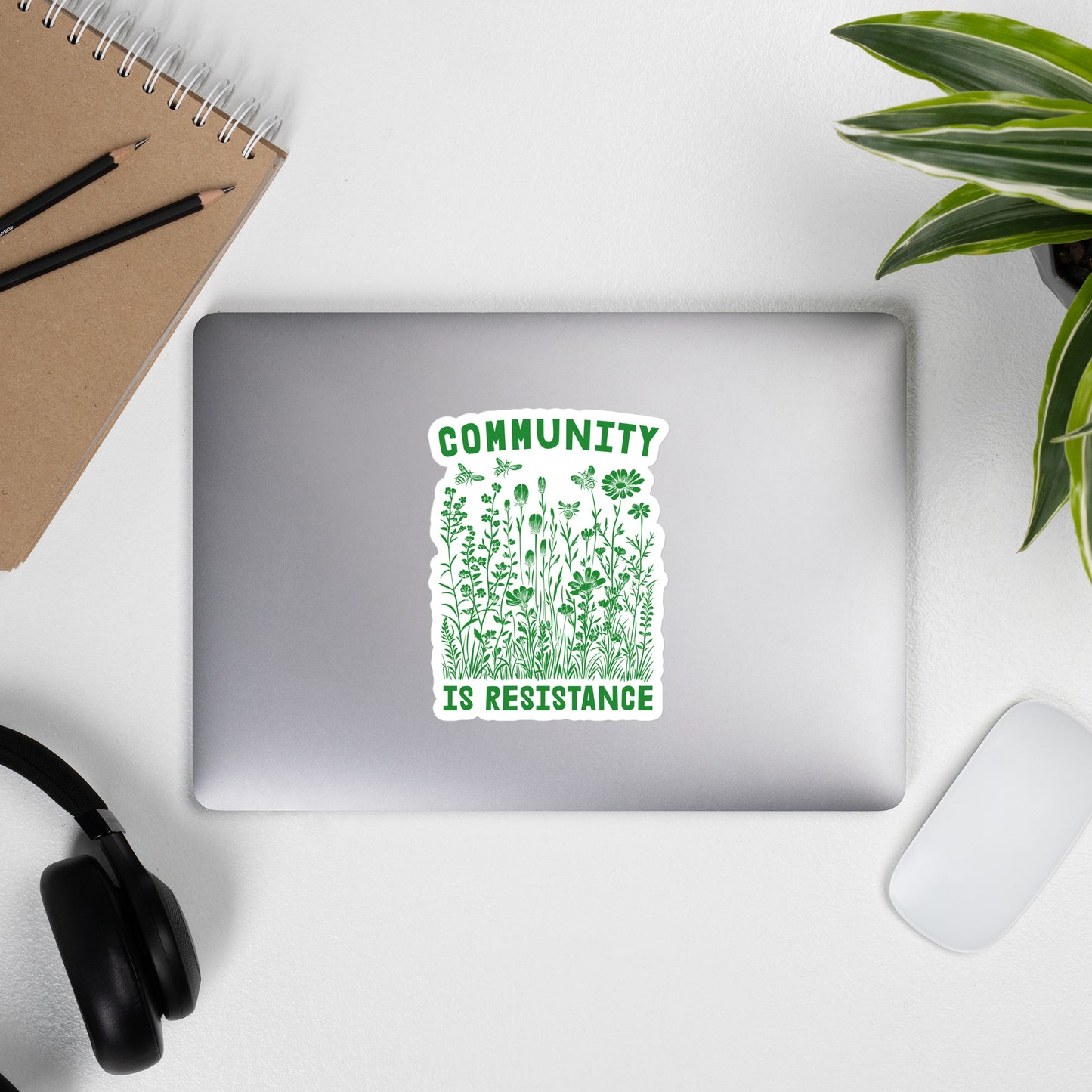 Lifestyle Image: Community Is Resistance Sticker displayed on a laptop