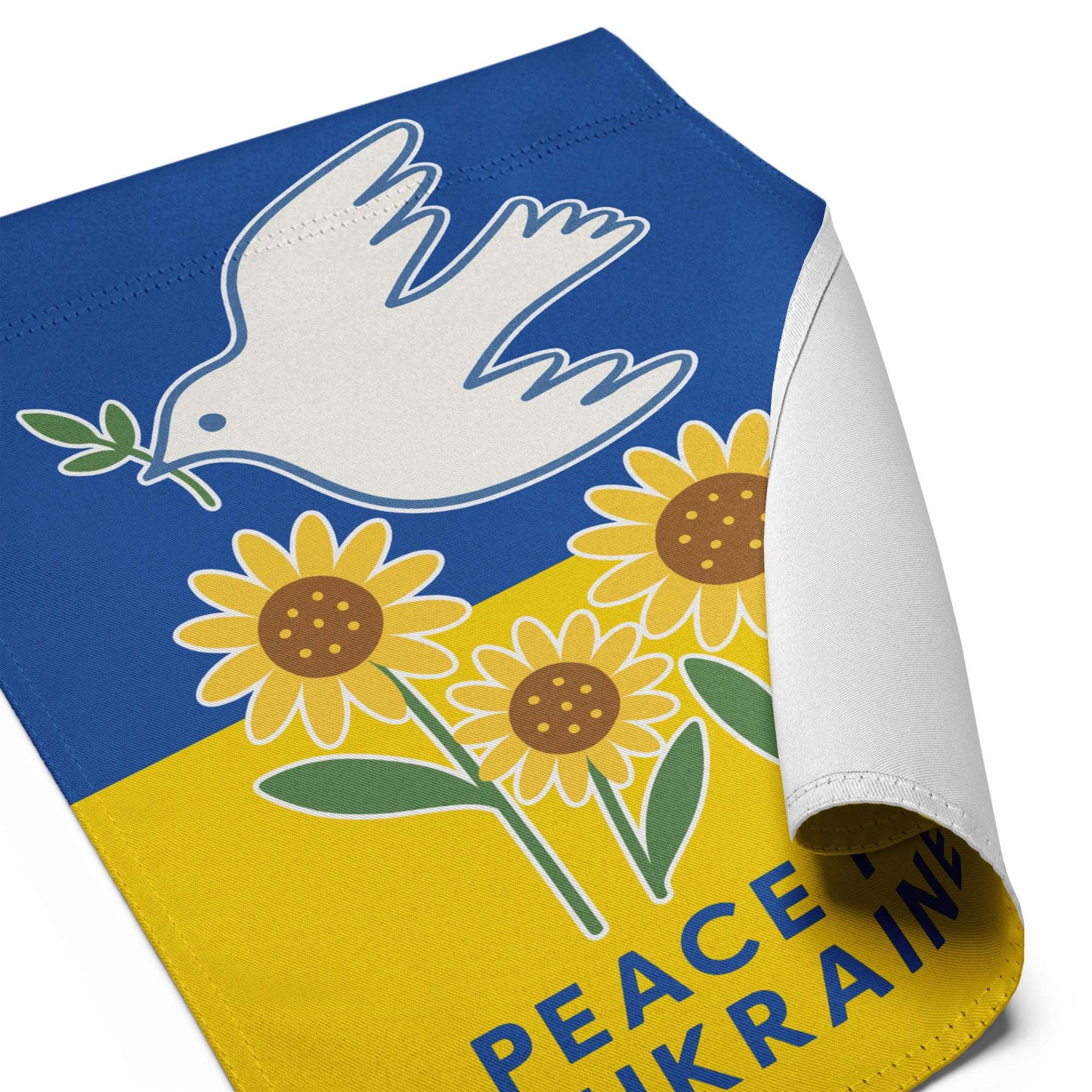 Close-up of the “Peace for Ukraine” activist garden flag with curled edge, showing dove and sunflower detail, Blue Wave USA progressive décor.