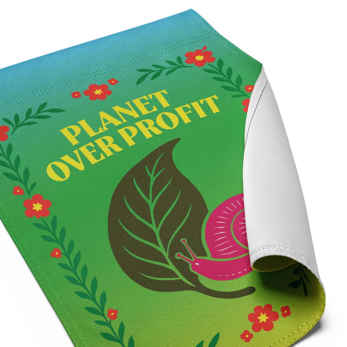 Close-up of the “Planet Over Profit” environmental garden flag with curled corner showing snail and floral details, Blue Wave USA progressive décor