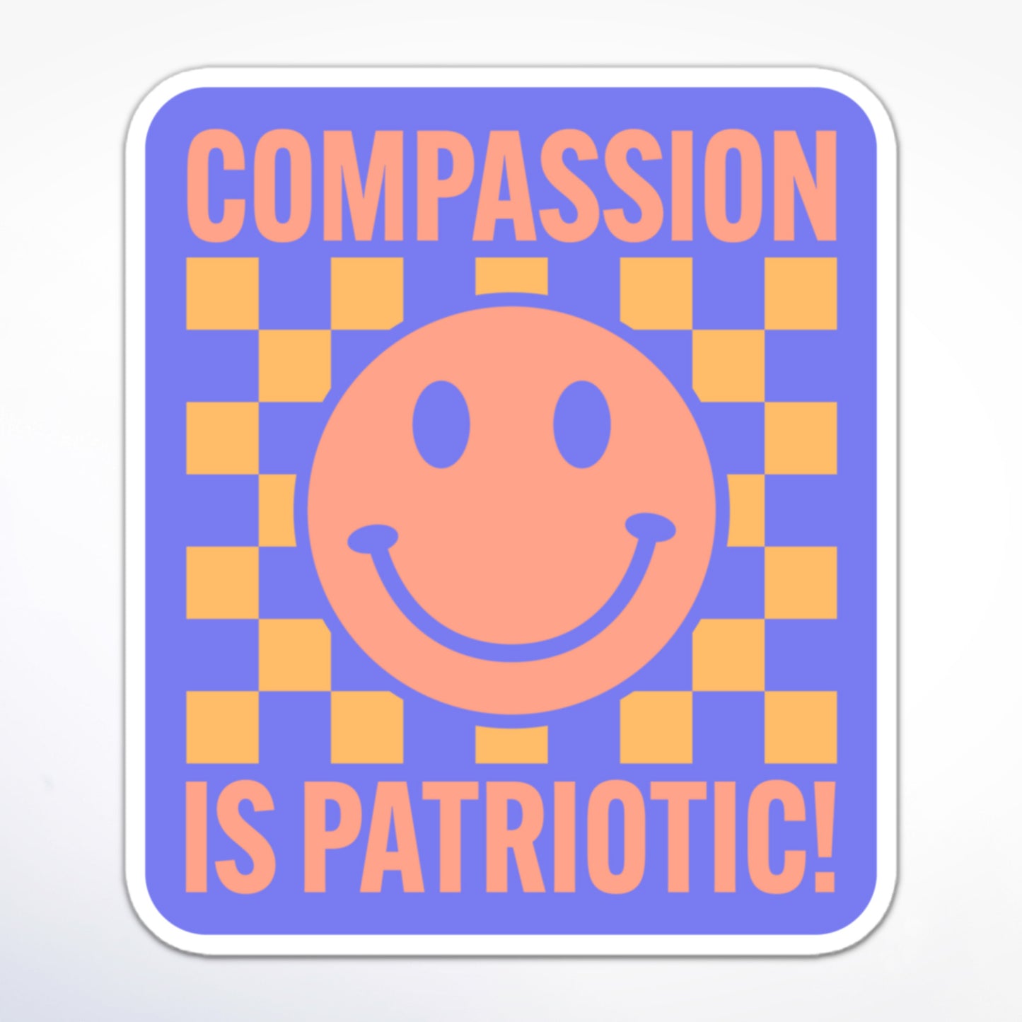 Progressive activism sticker with a happy face, yellow and purple checkerboard, and the message “Compassion is Patriotic!” in a bold font.