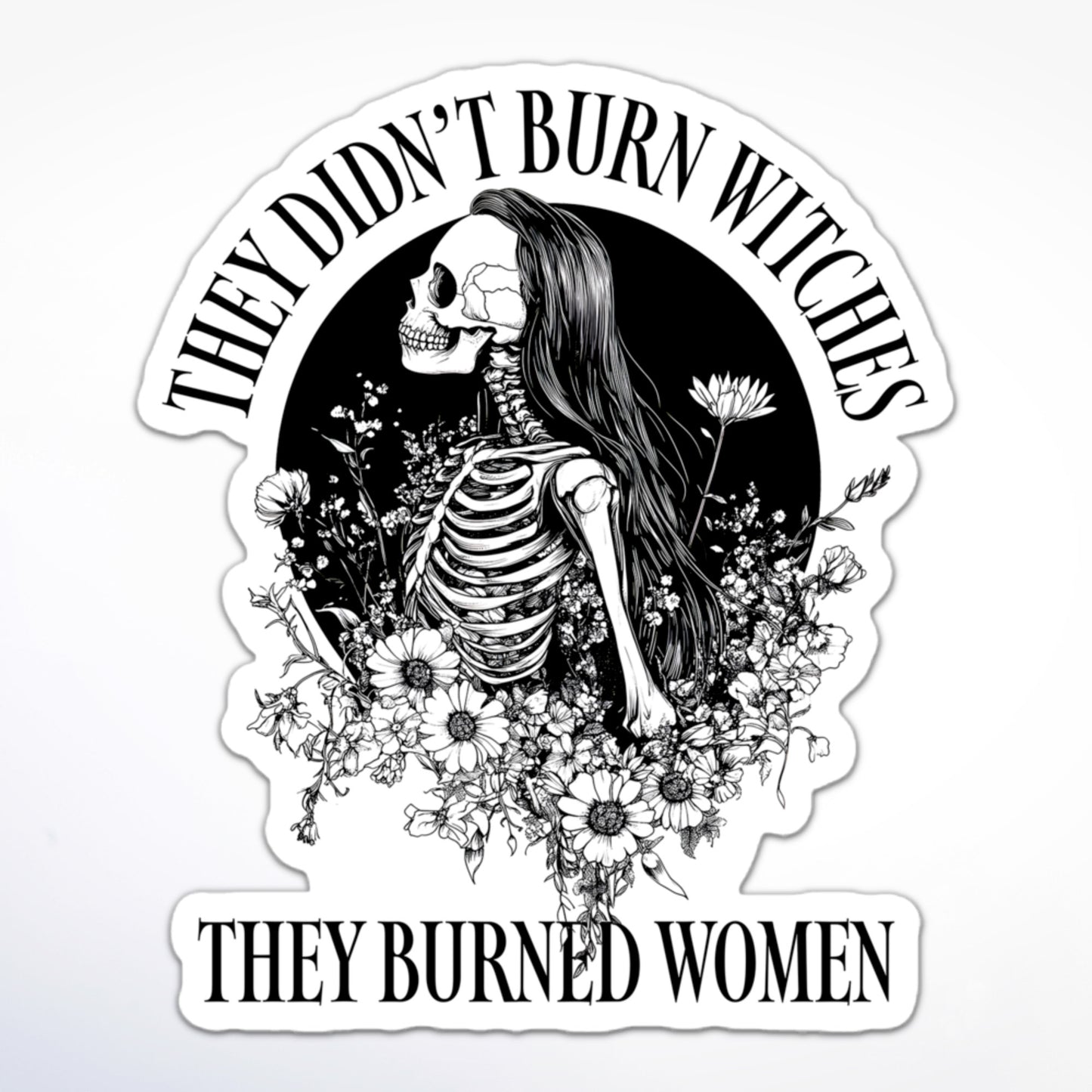 Feminist sticker featuring a female skeleton with long hair and flowers, encircled by the phrase “They Didn’t Burn Witches, They Burned Women.”