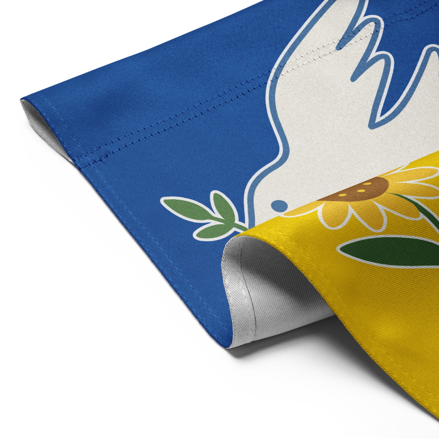 Close-up of the Ukraine Solidarity progressive garden flag with curled edge showing dove and sunflower detail, Blue Wave USA activist décor.