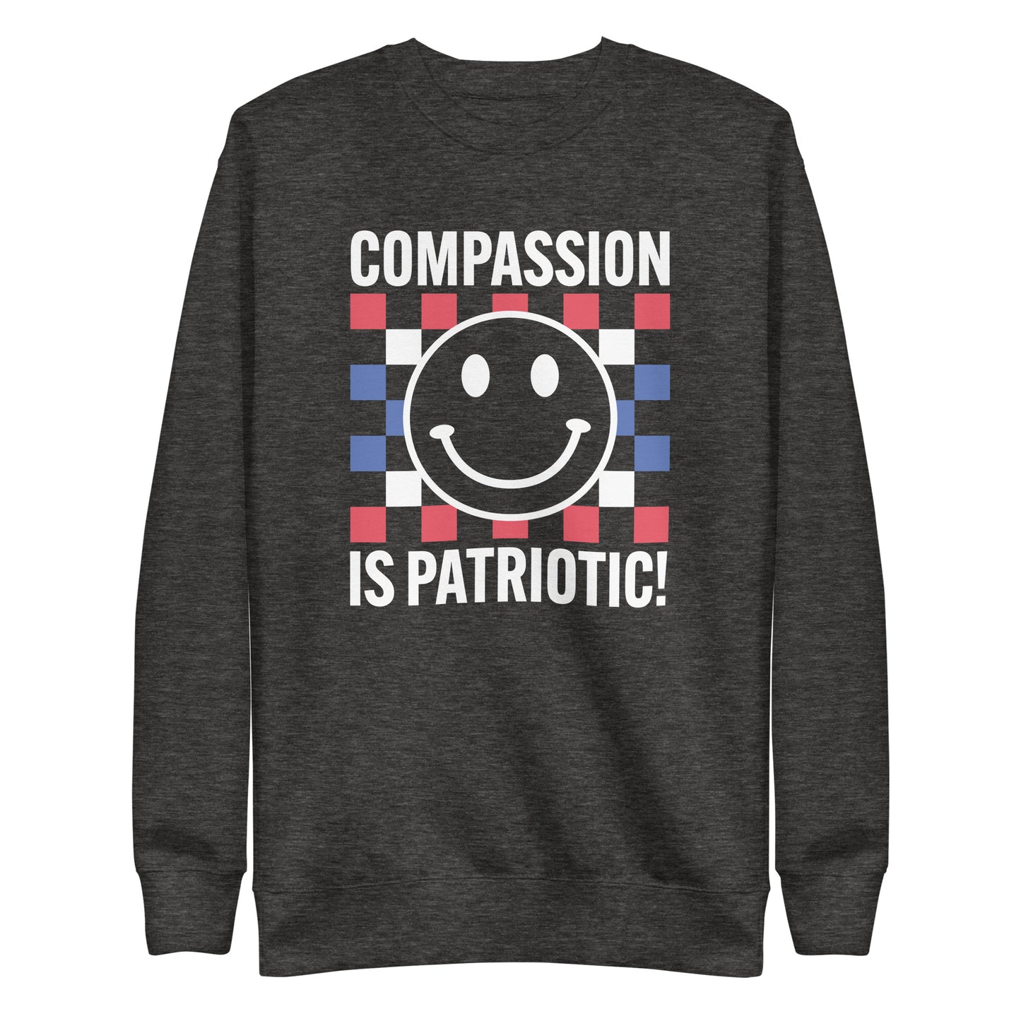 Front view of the Compassion Is Patriotic Premium Unisex Sweatshirt in red, white, and blue featuring a smiley face and bold text.