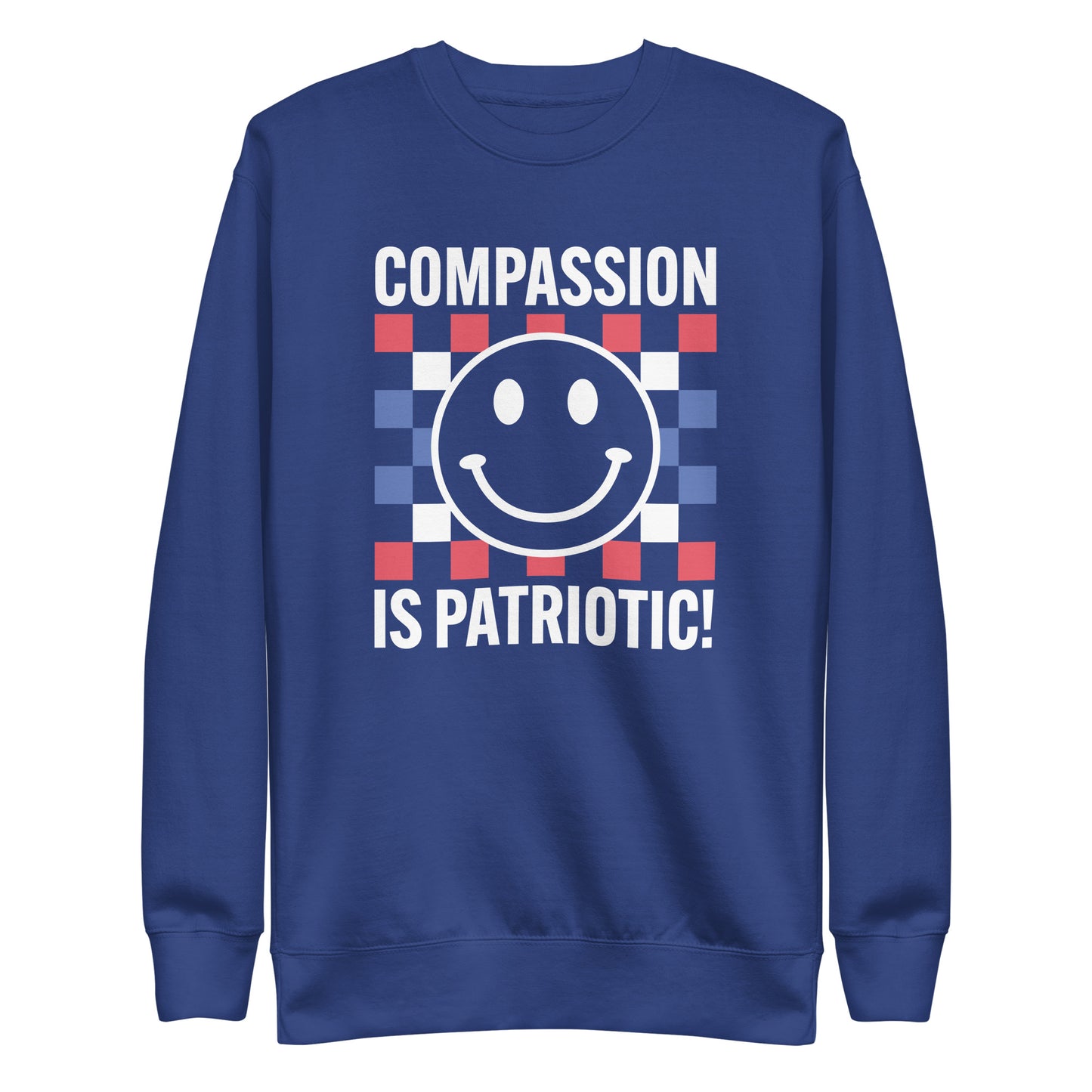 Front view of the Compassion Is Patriotic Premium Unisex Sweatshirt in red, white, and blue featuring a smiley face and bold text.