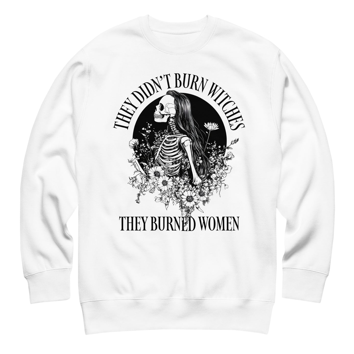 White unisex premium sweatshirt laid flat featuring gothic skeleton illustration framed by stars and flowers, centered circular layout, printed message “THEY DIDN’T BURN WITCHES THEY BURNED WOMEN.”