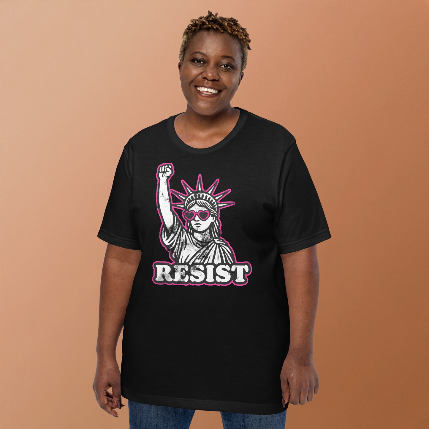 Lifestyle Image: Model protester wearing the RESIST feminist t-shirt with raised fist Statue of Liberty and pink heart sunglasses - black