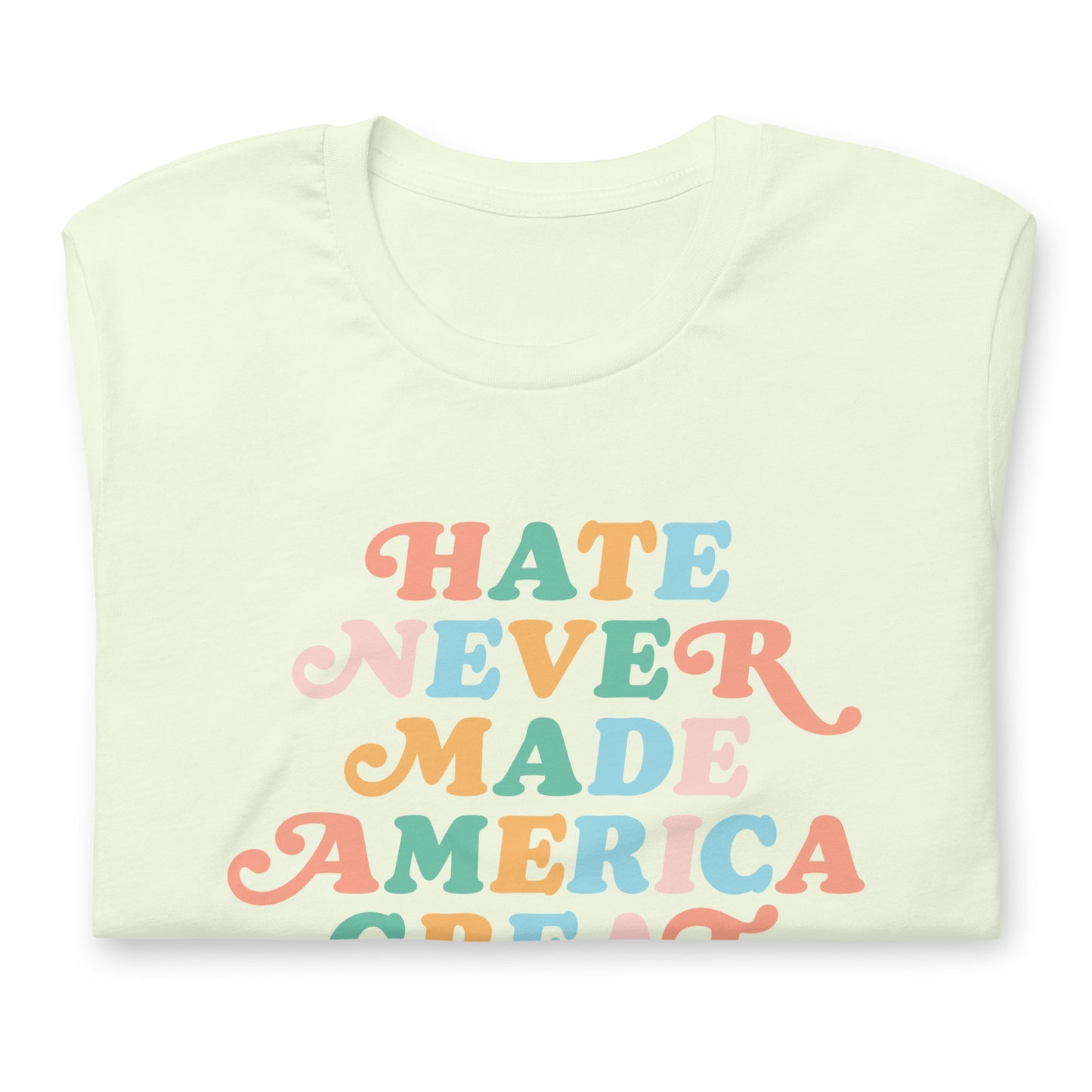 Close-up of Flat lay of cream t-shirt reading “Hate Never Made America Great” in rainbow retro letters.
