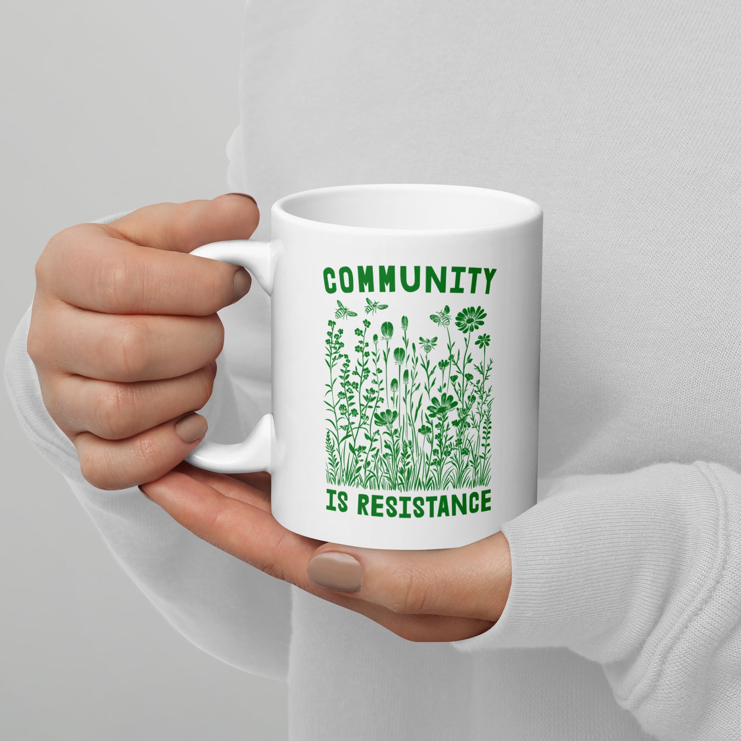 Close-Up of Design: Detailed view of the 11 oz "Community Is Resistance" message on the mug.