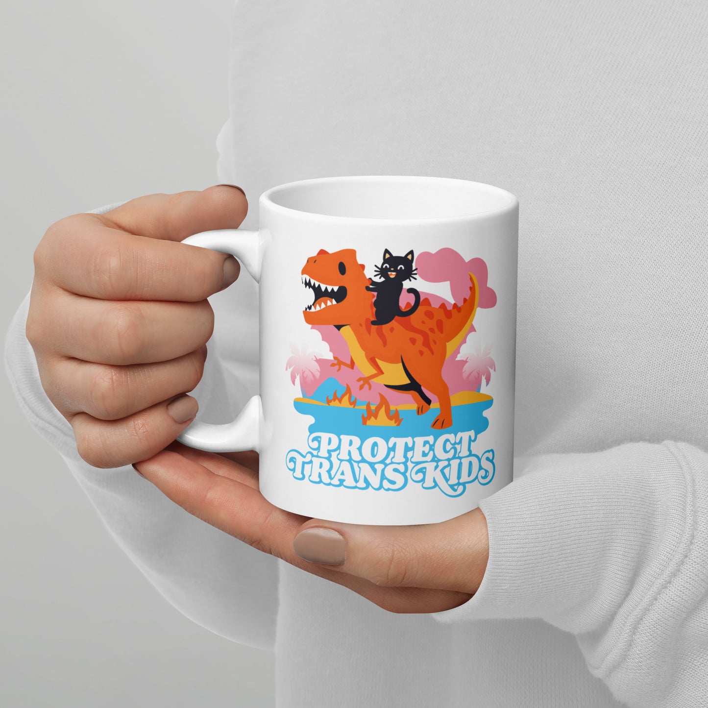 Person holding 11 oz Protect Trans Kids Mug while enjoying a hot beverage.