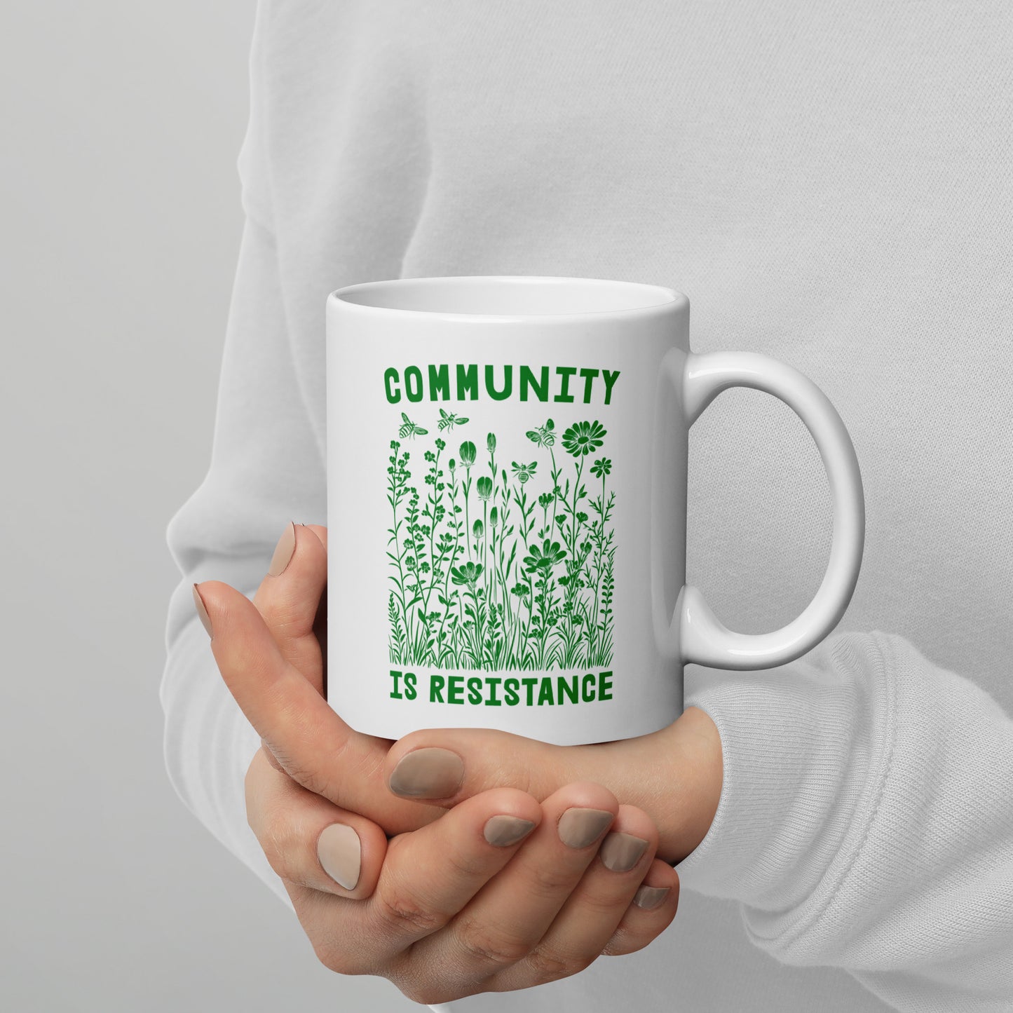 Close-Up of Design: Detailed view of the 11 oz "Community Is Resistance" message on the mug.