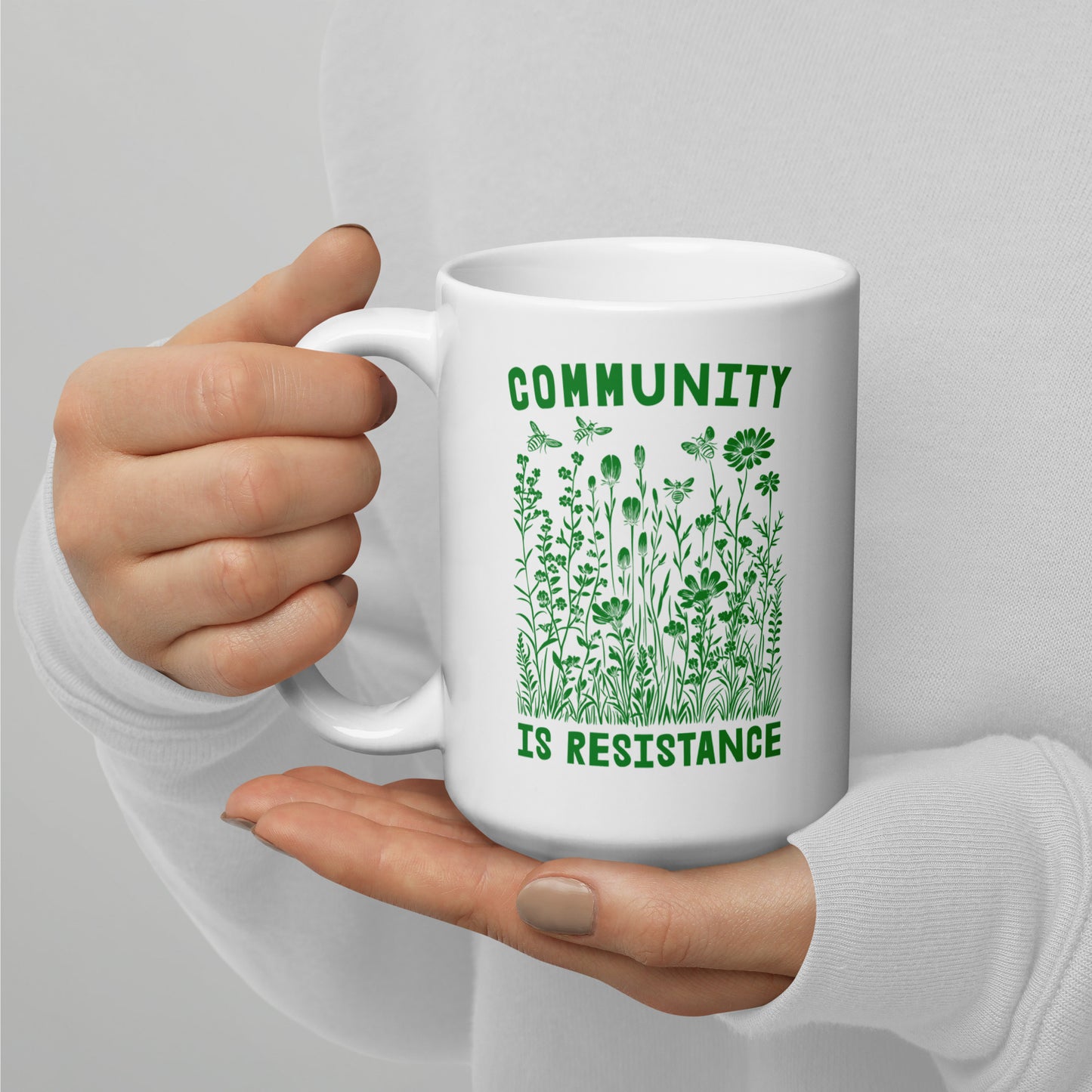 Close-Up of Design: Detailed view of the 15 oz "Community Is Resistance" message on the mug.