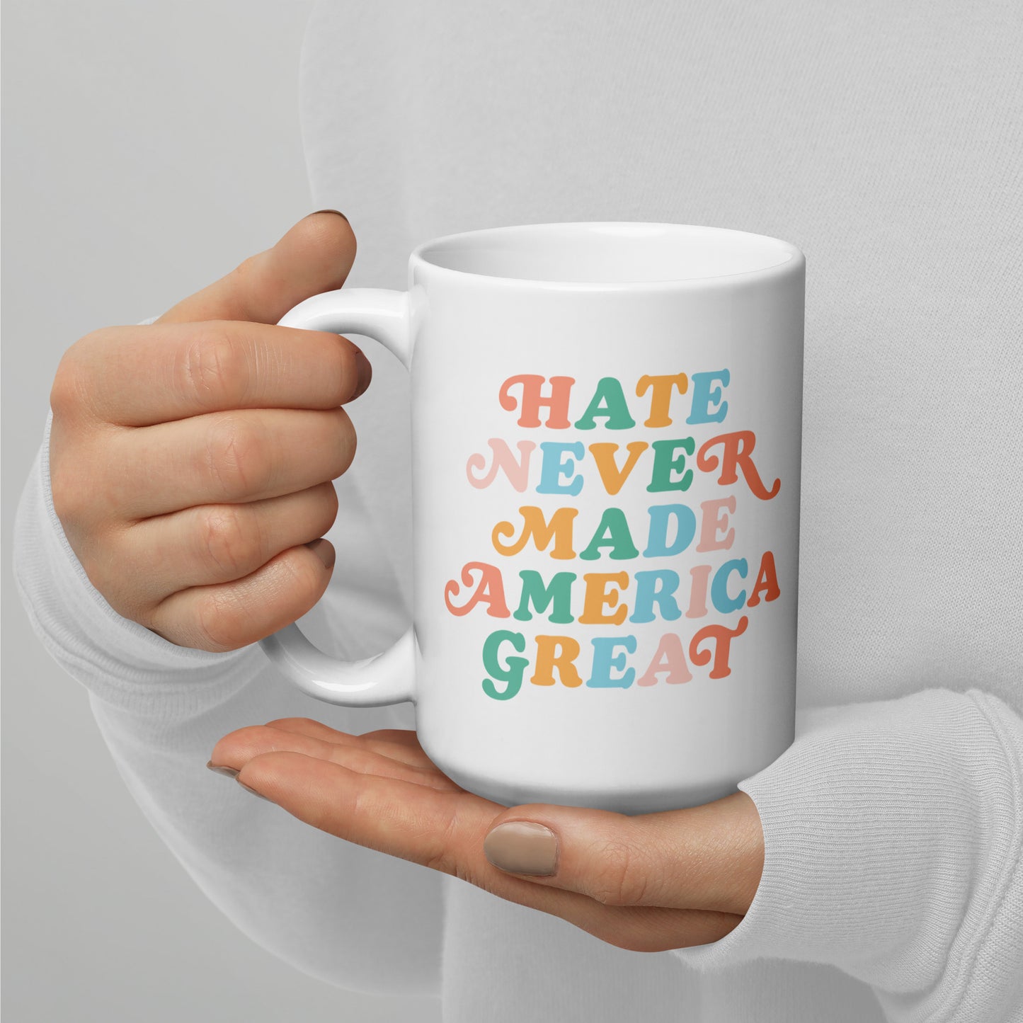 Full view of the 15 oz white mug featuring Hate Never Made America Great.