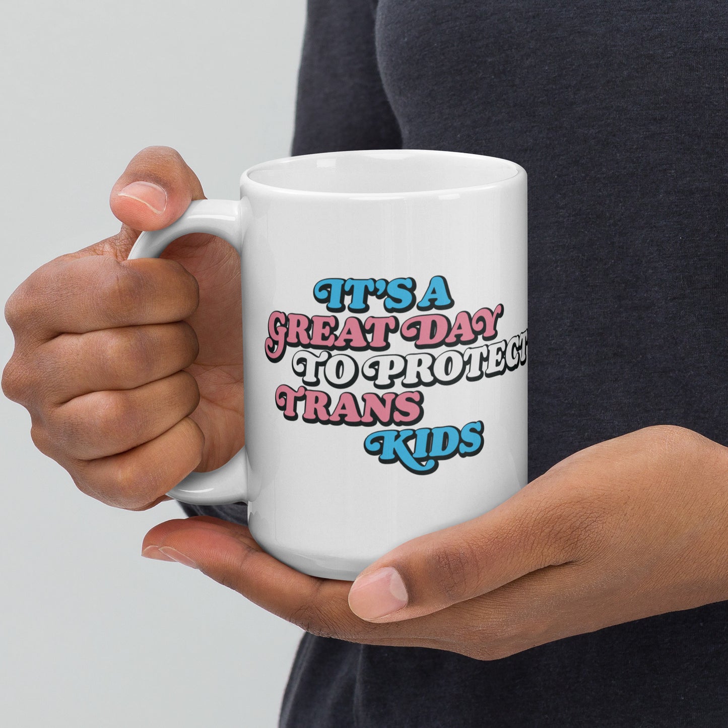 Lifestyle Image: Person holding 15 oz It’s A Great Day To Protect Trans Kids White Mug